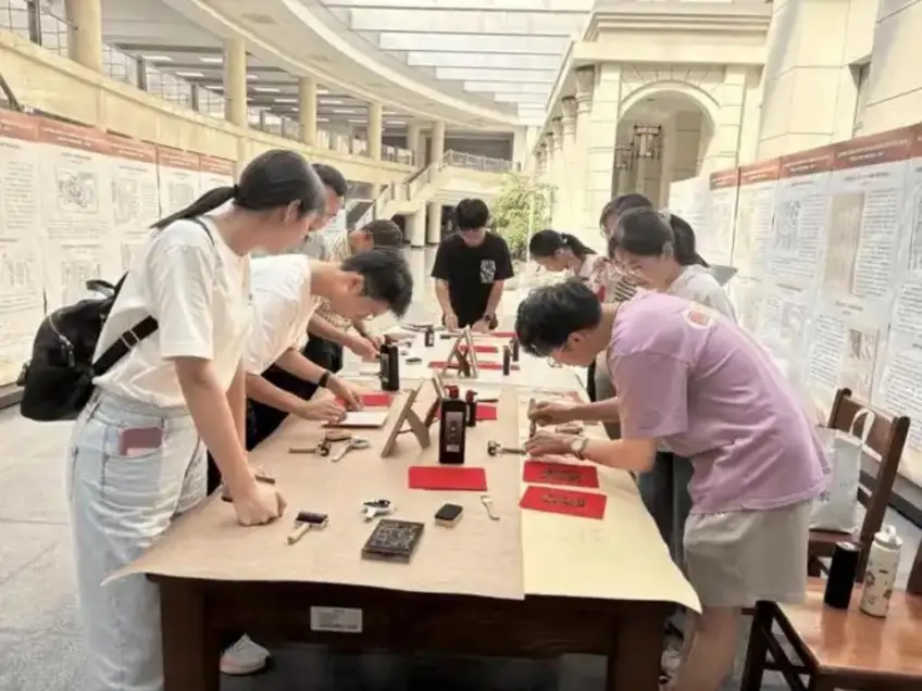 雕版印刷体验区游客围桌刷墨拓印