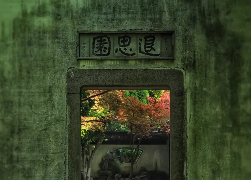退思园门额与门内红枫扇窗
