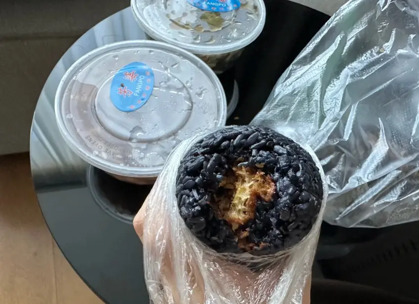 手持烏飯糰咬開露餡料近景
