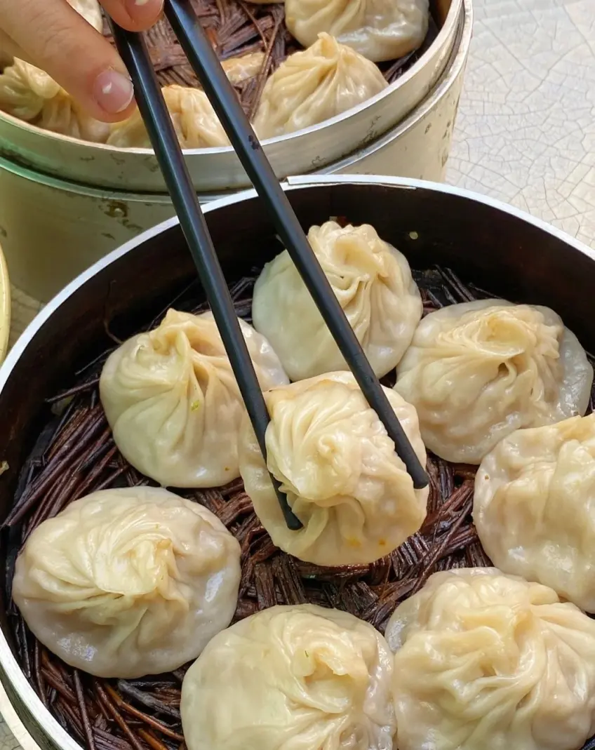 竹籠鮮肉湯包筷子揭起近景示意