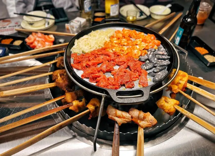火盆烤肉桌上炭火与竹签串肉
