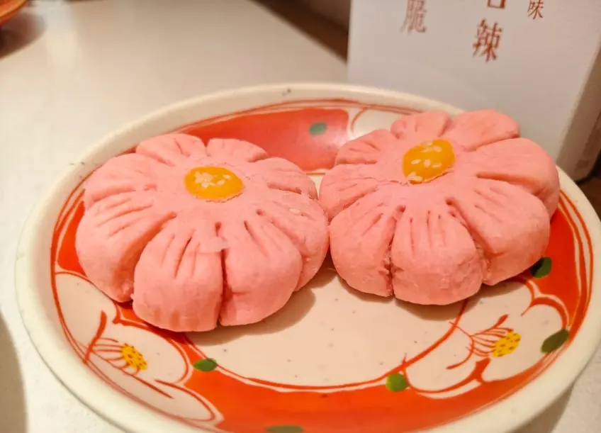 粉紅梅花糕兩隻配紅紋盤近景