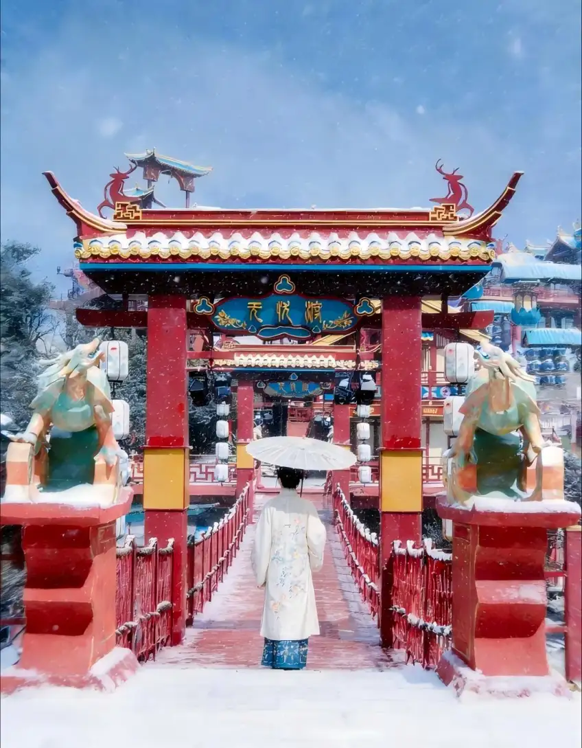 汉服游客撑伞立雪桥眺望仙侠山门