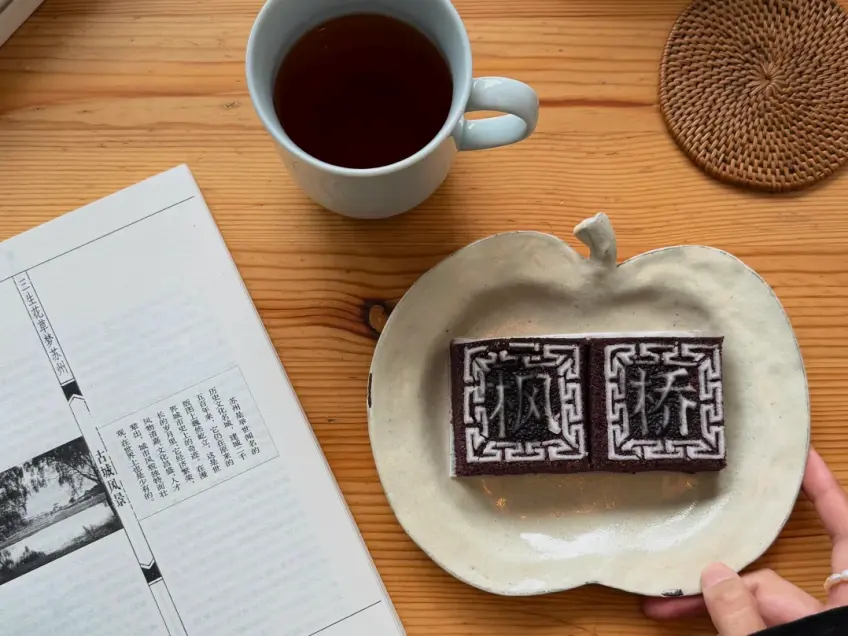 枫桥字样黑米糕与茶杯书册