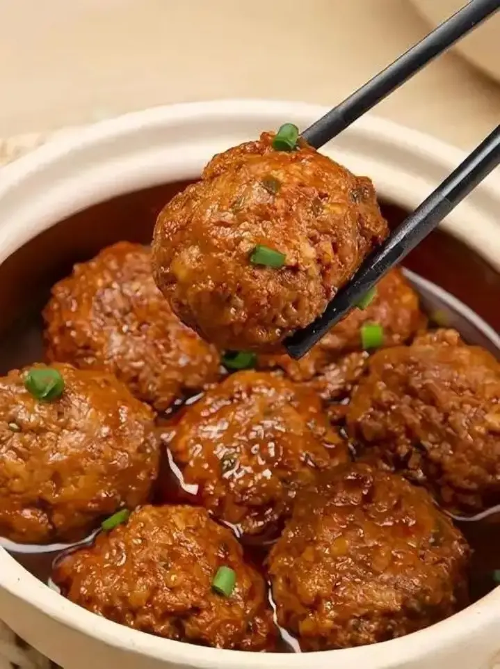 砂锅红烧狮子头被筷子夹起特写
