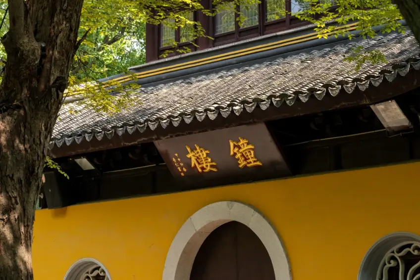 寺庙黄墙钟楼匾额与两侧圆窗
