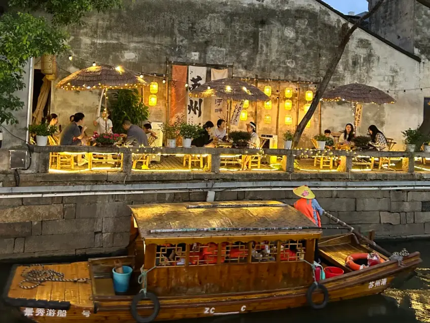 黄昏摇橹船驶过灯火临河茶座