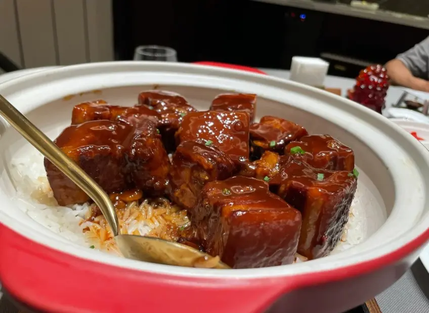 砂鍋紅燒肉塊配米飯金勺近景