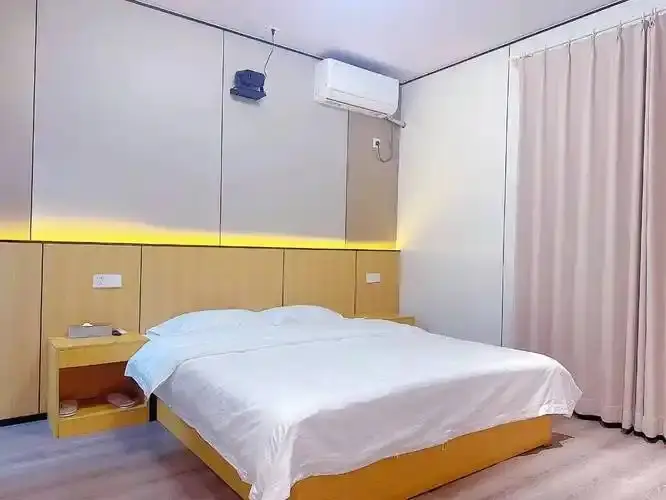 本地宾馆简约大床房暖光灯带与浅木床头