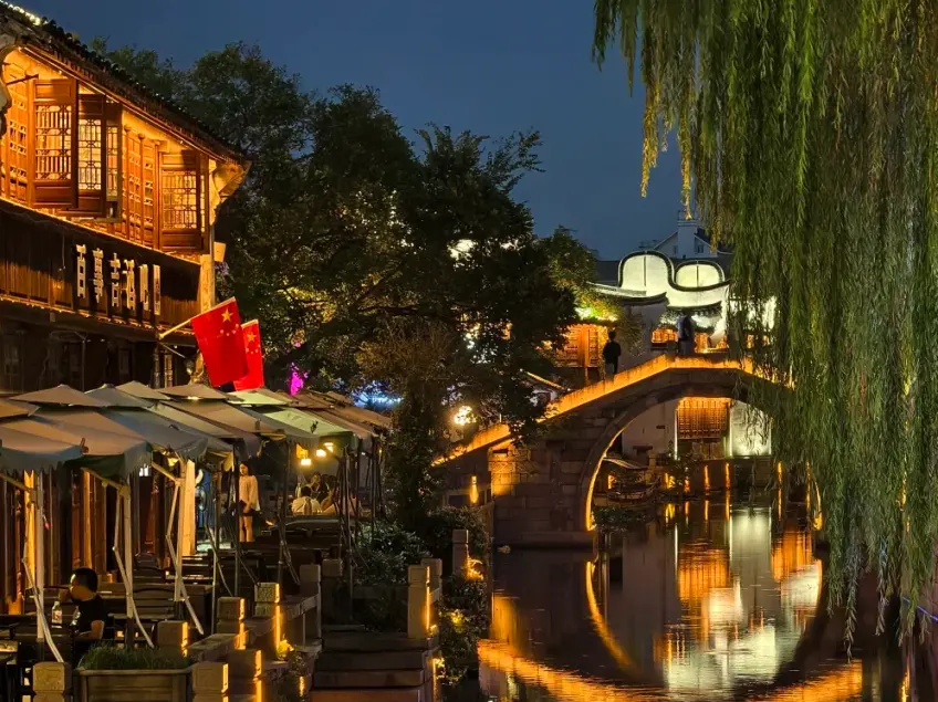 夜色石桥灯圈倒影与临水餐伞