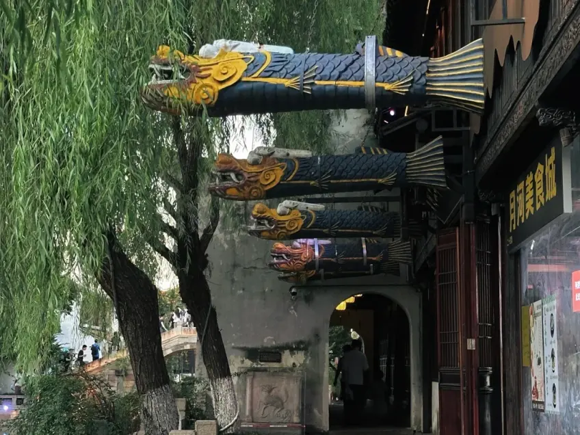 廊下蓝绿橙鱼形灯笼与柳枝石桥