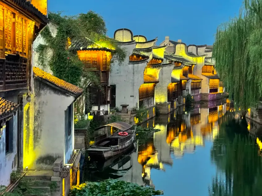 月河夜景暖黄灯火倒影与靠岸木船