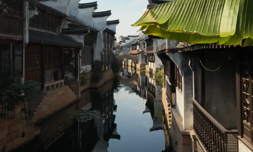 暮色河湾吊楼轮廓与水面倒影