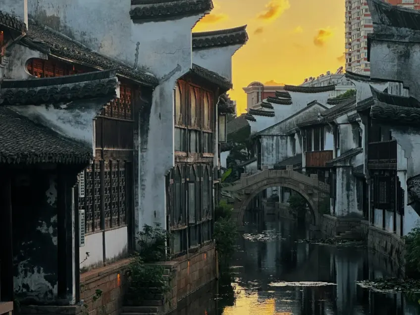 月河巷弄白墙黑瓦与拱桥暮色