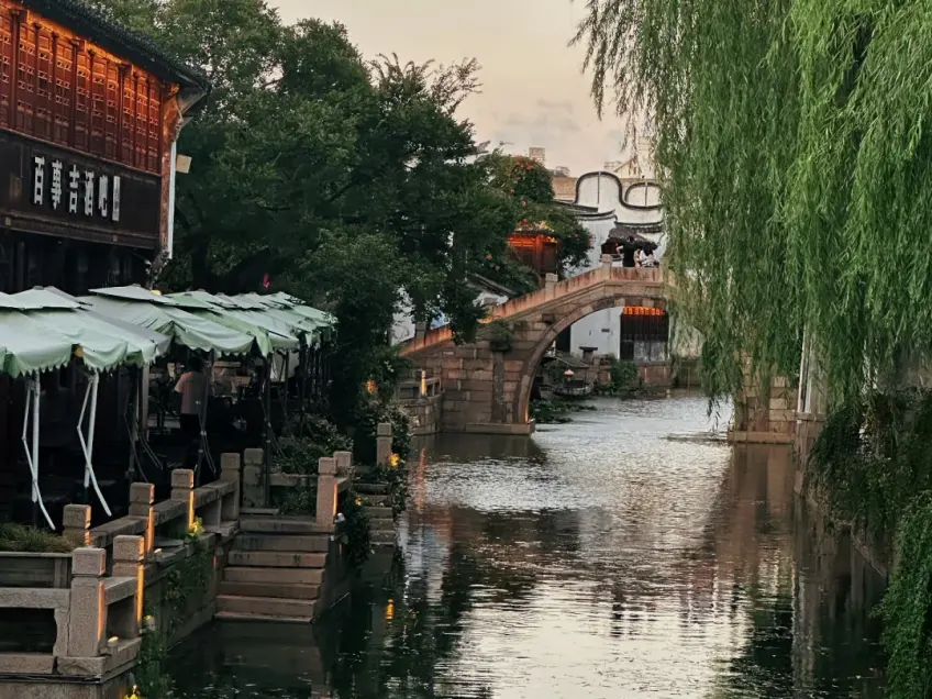 黄昏运河石拱桥与百事吉酒楼临水座椅