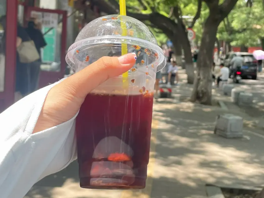 手持冰镇酸梅汤街边杯