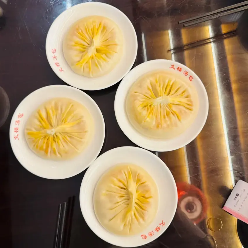 文楼蟹黄汤包四白瓷盘俯拍示意