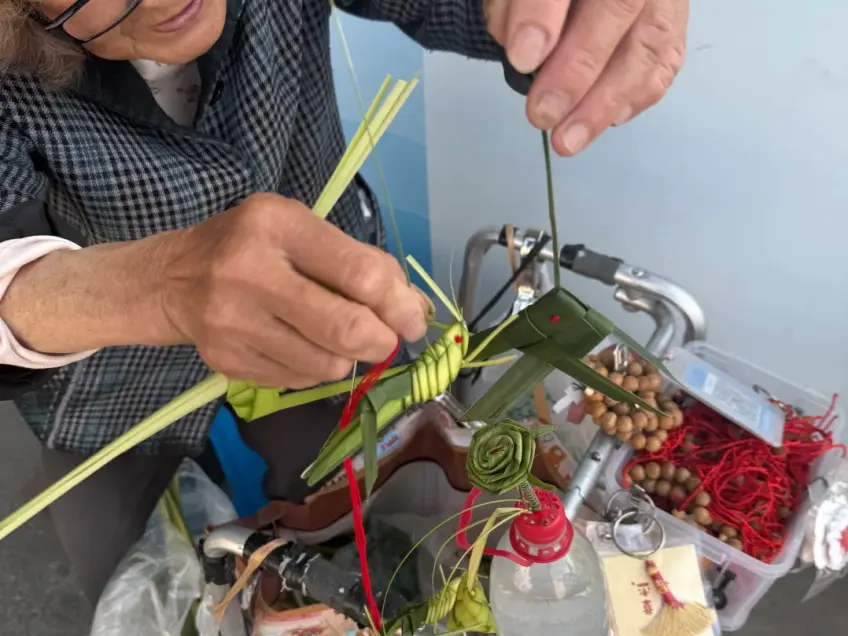 老妇现场棕编蚂蚱草虫手作