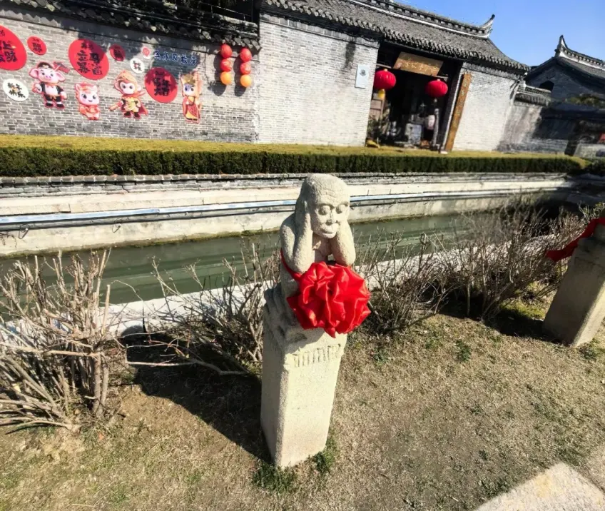 河岸石猴红绸与故居砖墙彩绘