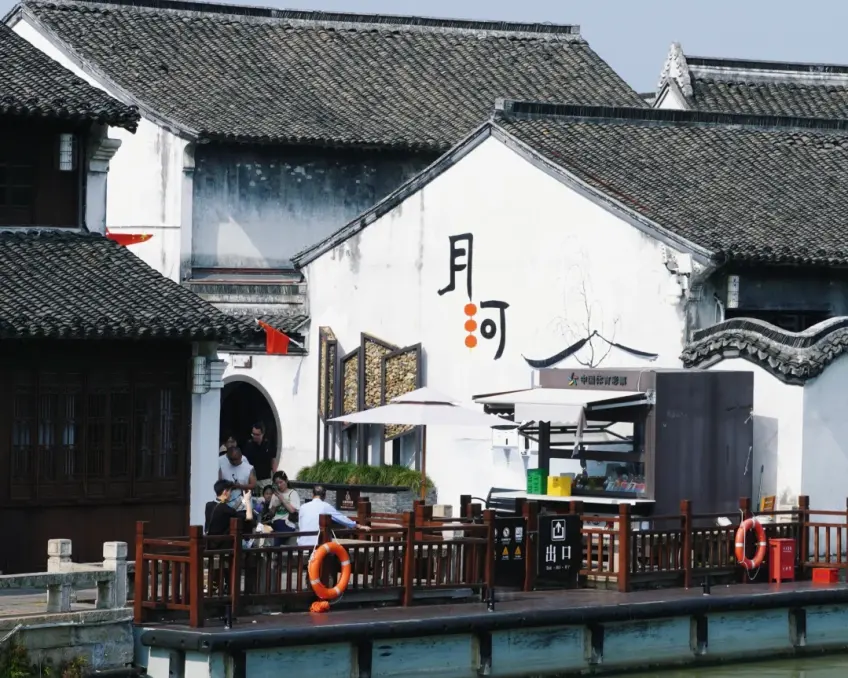 写有月河二字白墙与木栈道救生圈