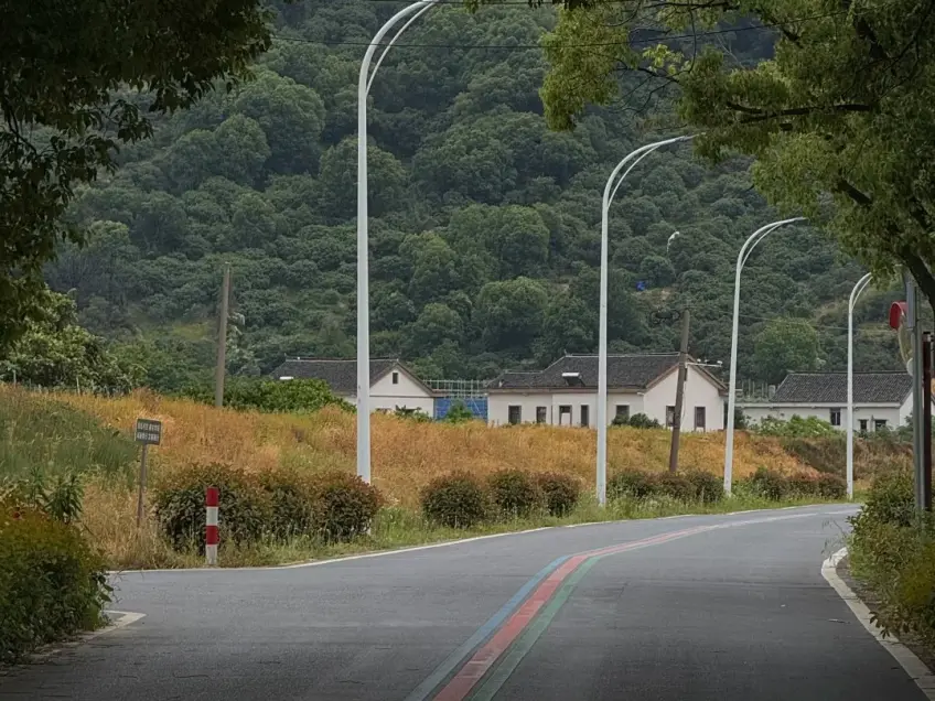彩色标线骑行道与山间白墙民居