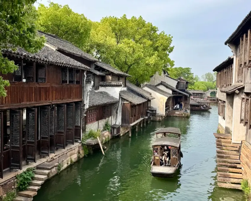 两岸木楼石阶间河道乌篷船缓行