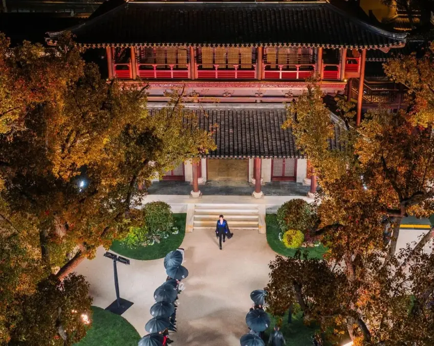 夜间亮灯木构楼阁红叶与伞阵步道