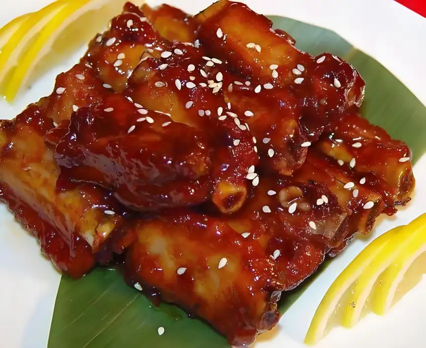 無錫醬排骨白芝麻點綴綠葉盤裝