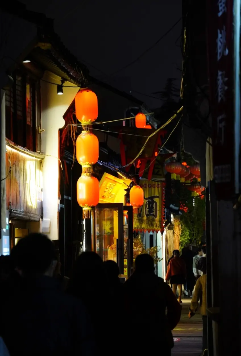 無錫南下塘夜巷橙燈籠與行人背影