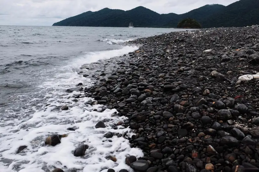 烏石塘黑卵石灘與拍岸浪花遠山