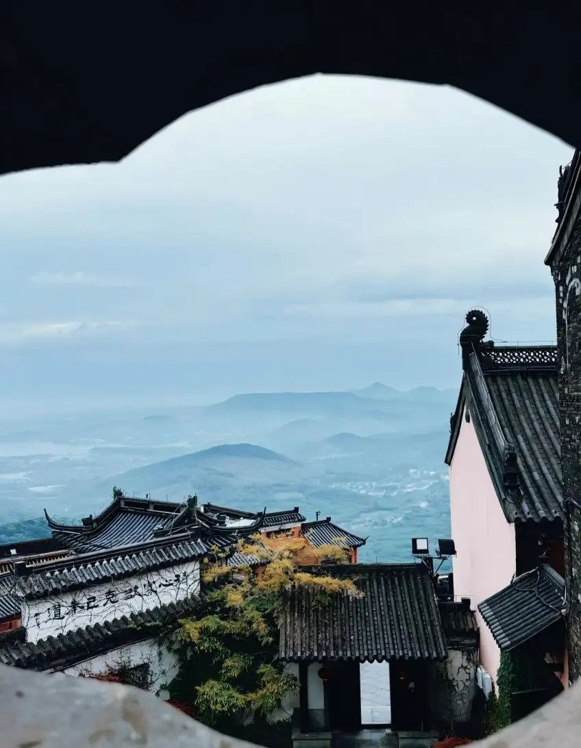 圓形月洞門框外茅山道觀屋頂與遠山霧氣