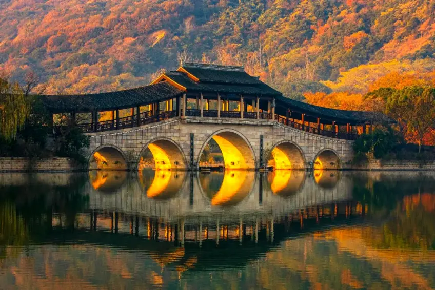 五孔石拱廊橋與秋山暖光倒影