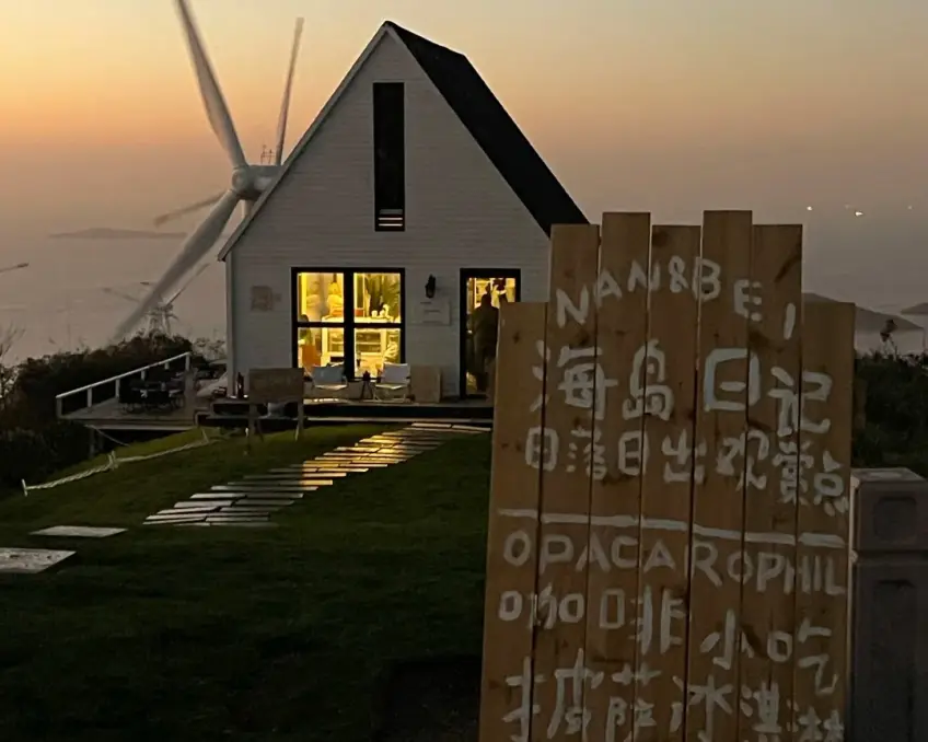 島上咖啡館木牌與白色風機夕陽