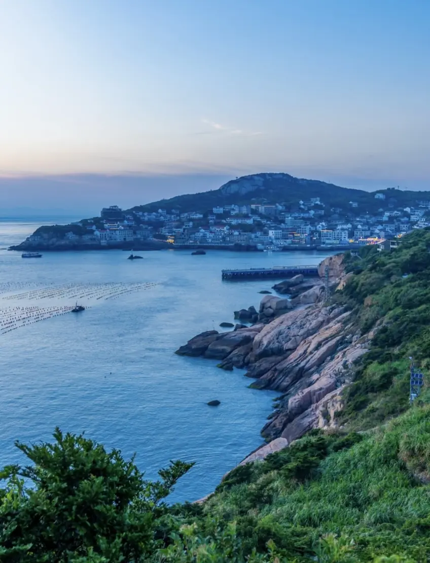 黃昏灣對岸漁村燈火與浮排