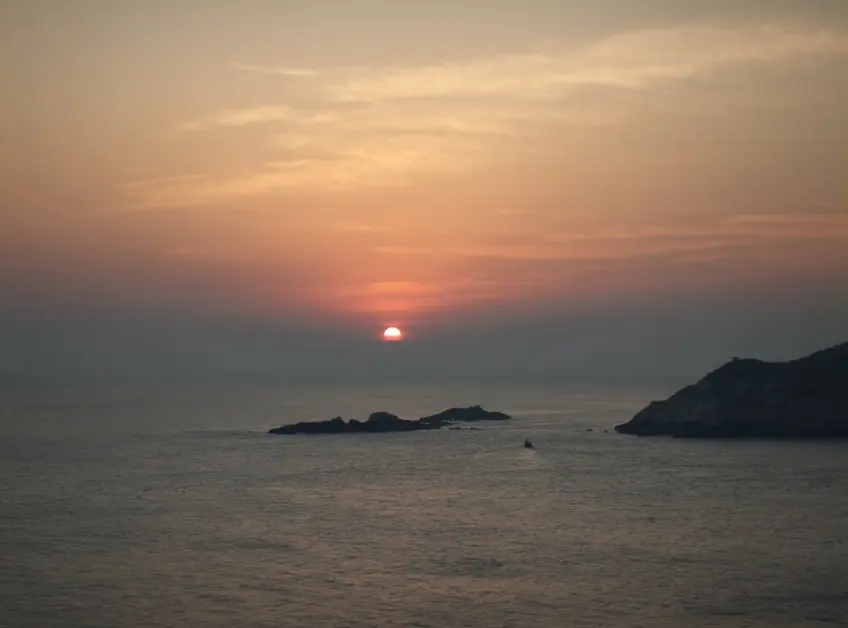 海平面紅日與礁岩剪影