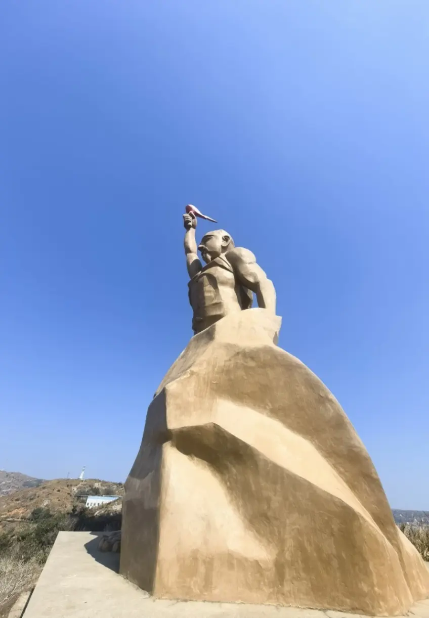 財伯公舉火雕像仰拍與藍天