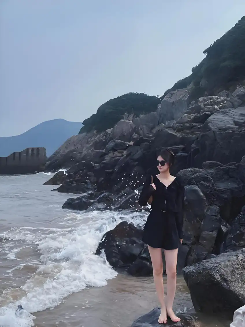 礁石岸拍浪人像墨鏡黑衣打卡