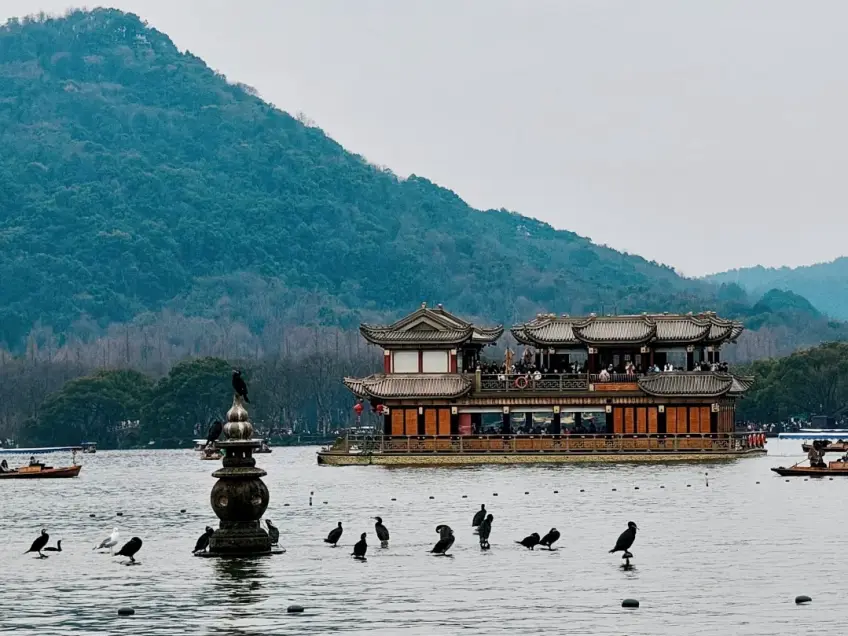 湖面畫舫與石塔遠山同框