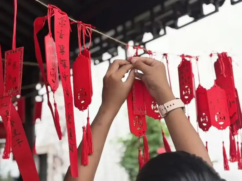 雙手系紅祈福牌木架近景特寫