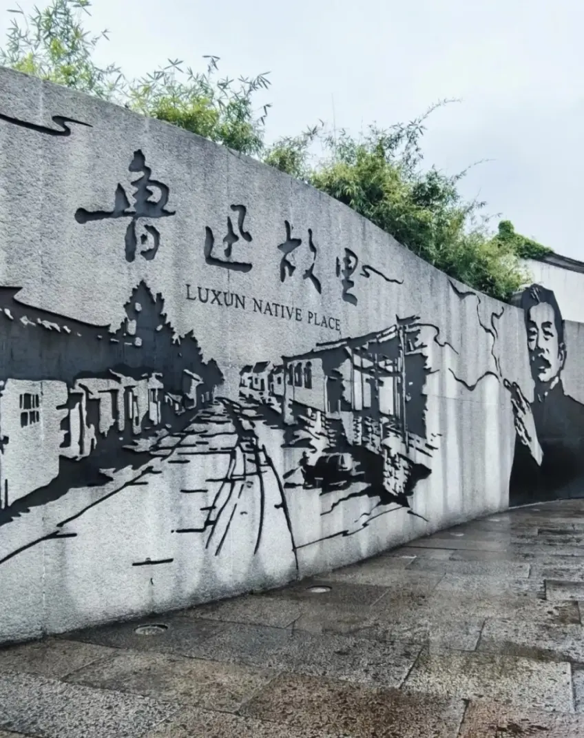 魯迅故里四字石壁與魯迅肖像浮雕雨後地面