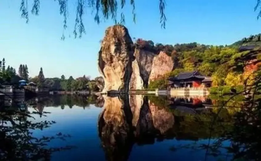 柯巖雲骨石柱倒映湖面與岸邊古建