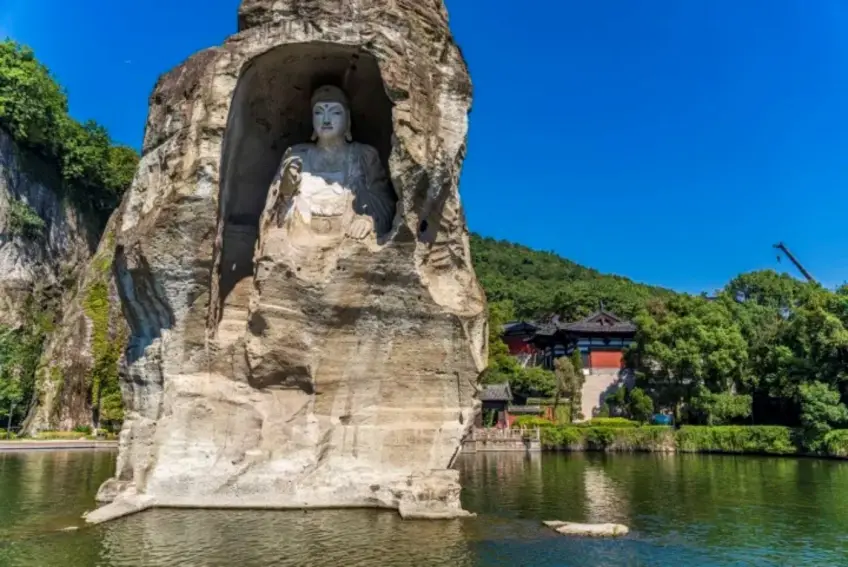柯巖水中石佛與遠岸山寺紅牆
