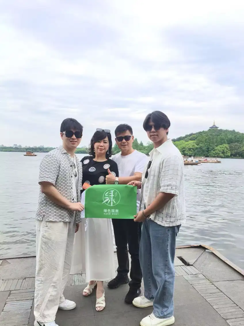 雷峰塔远景旁游客举绿旗合影