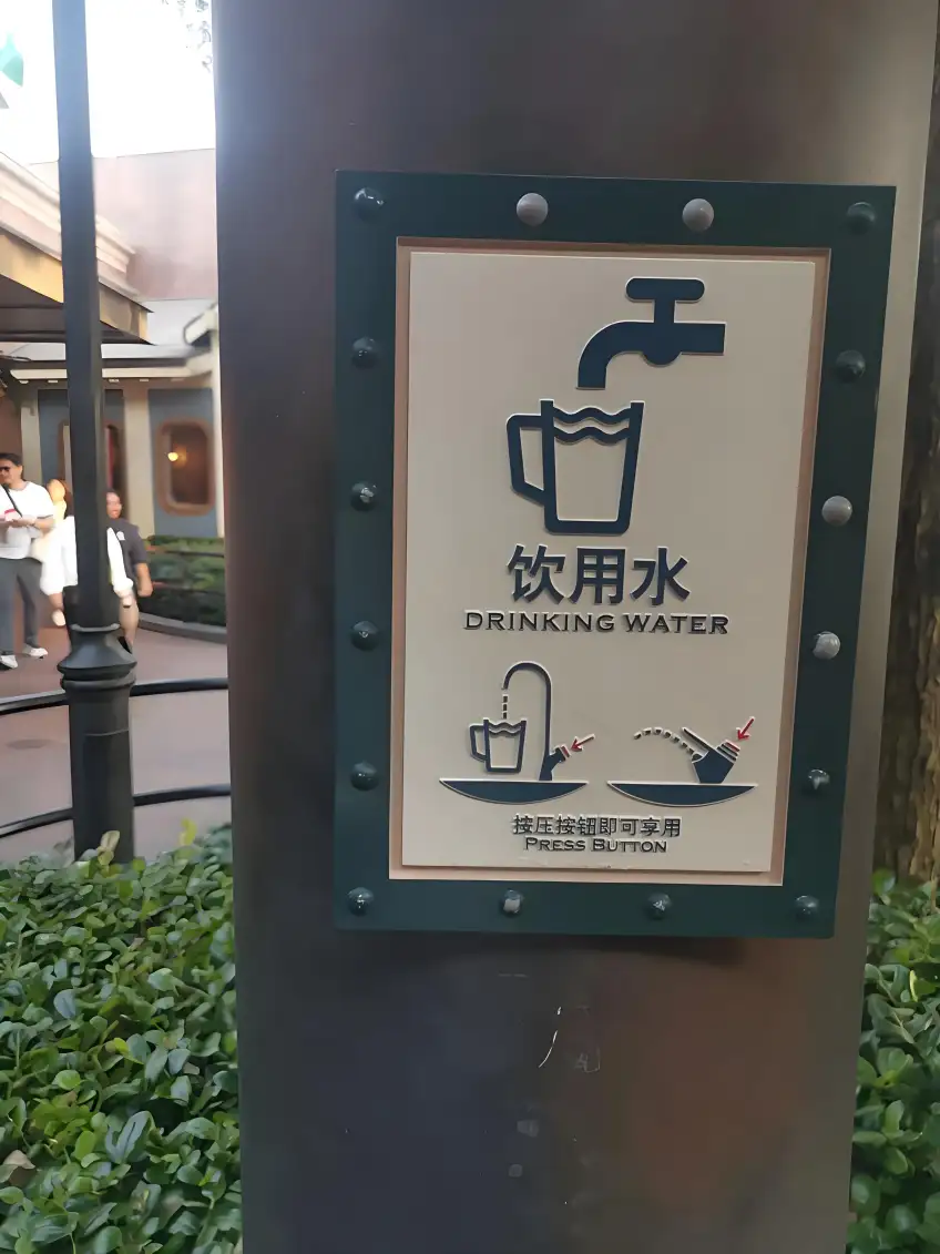 金屬柱上飲用水中英雙語標識與按壓示意圖示意