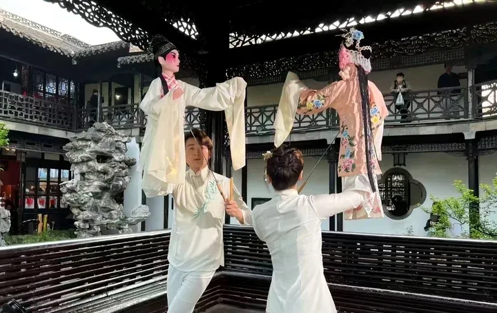 何园廊下木偶师举杖头木偶表演