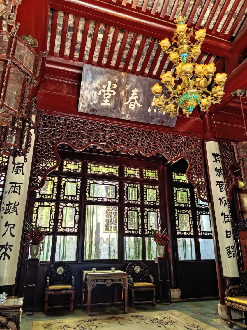 寄春堂匾額窗前桌椅與吊燈豎圖
