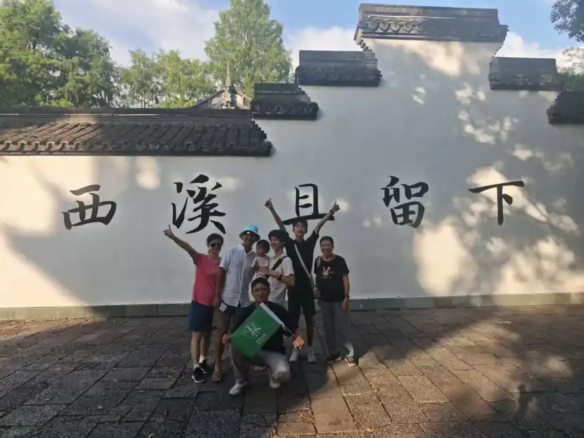 游客在西溪且留下白墙前合影
