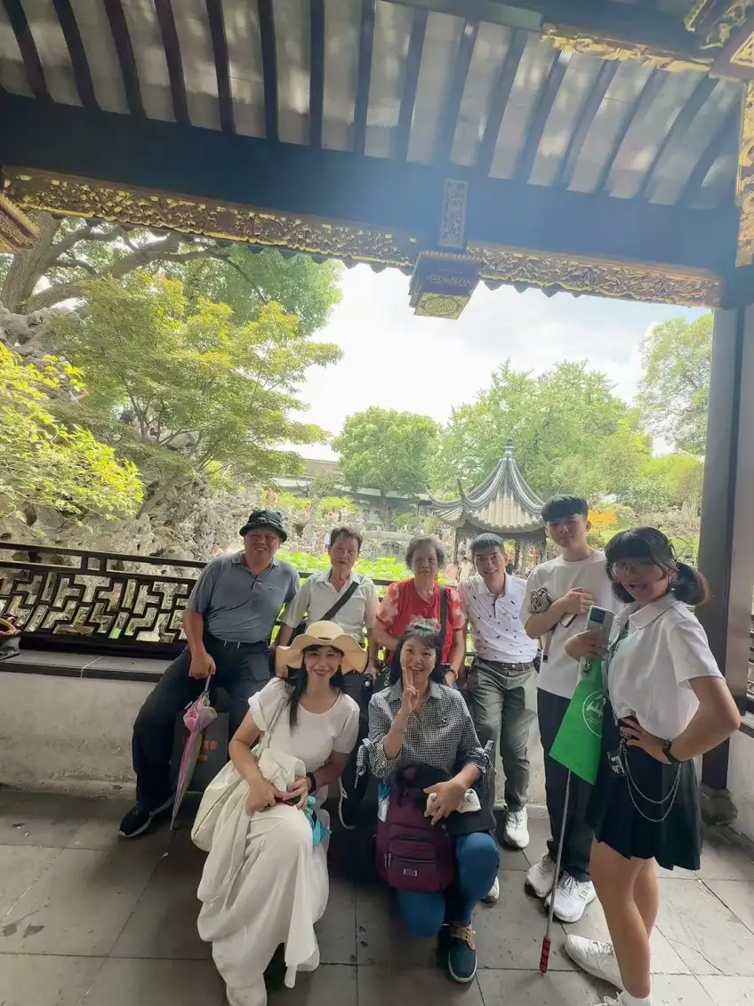 古典園林亭廊內多代遊客合影