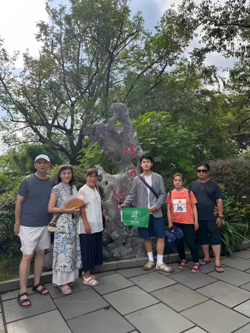 西湖園石碑前導遊遊客合影豎圖