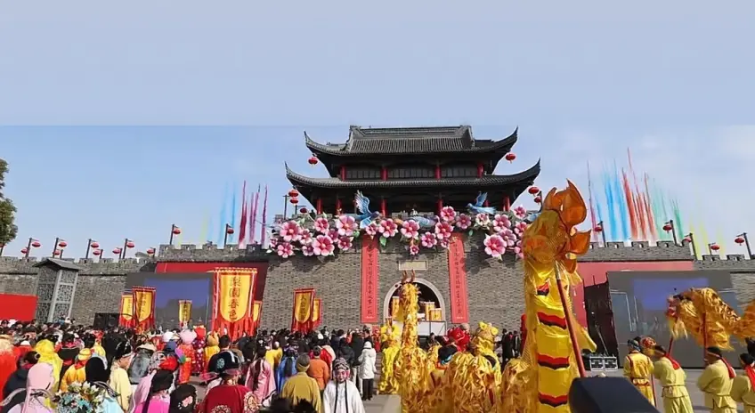 古城门前泰伯庙会舞龙与彩旗人群